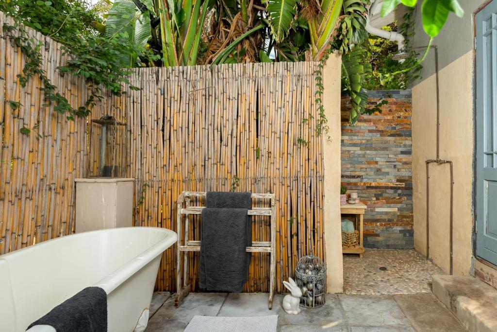 a bathroom with a bath tub and a wooden fence at Ukholo Lodge in Citrusdal