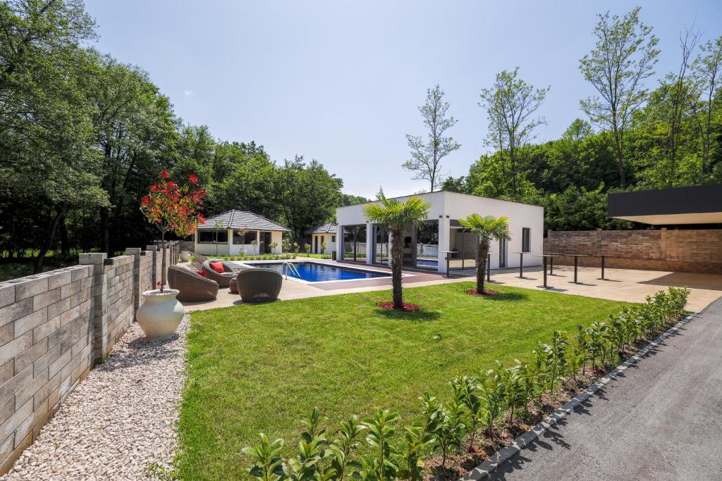 a backyard with a swimming pool and grass at Villa Diamond One in Banja Luka
