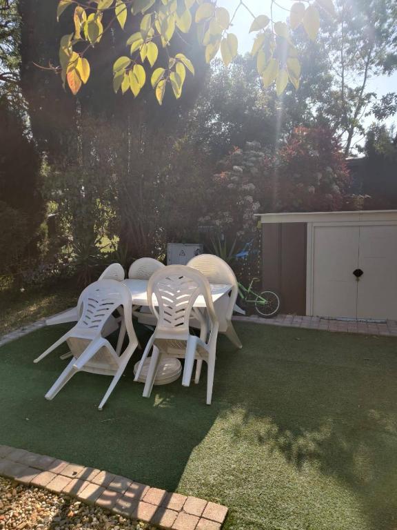 a table and chairs sitting on a lawn at MOBIL HOME CLIMATISE 2 CHAMBRES CLIMATISE CAMPING 4 ETOILES LE LAC DES REVES in Lattes