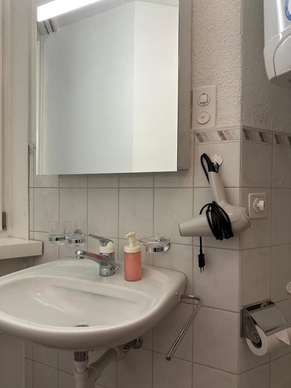 a bathroom with a sink and a white cabinet at tas24ch Travel and Sleep 24 in St. Gallen