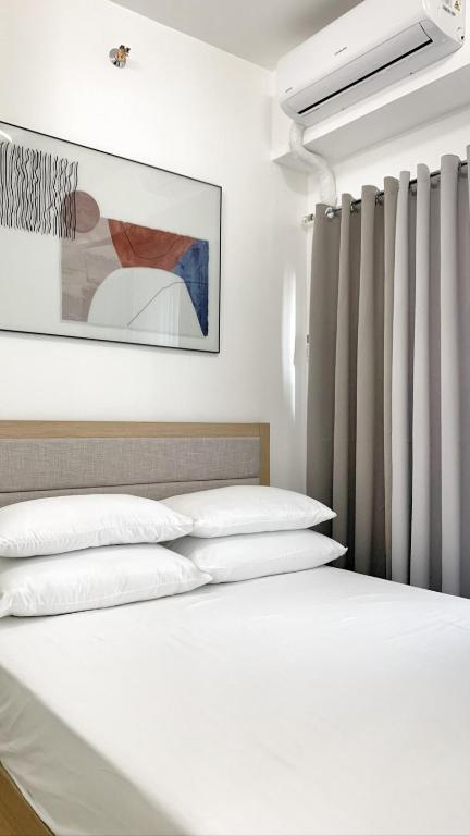 タガイタイにあるL. Casa • Tagaytay Staycationの白い枕と壁画付きのベッド