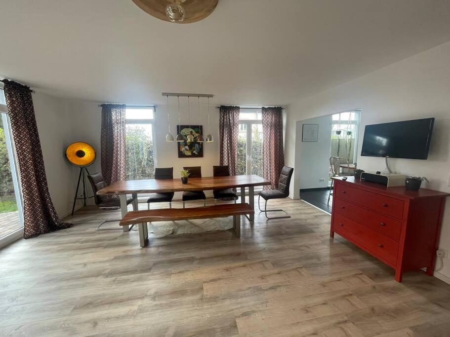 sala de estar con mesa de madera y cómoda roja en Urban house for families and Berlin tourists, en Teltow