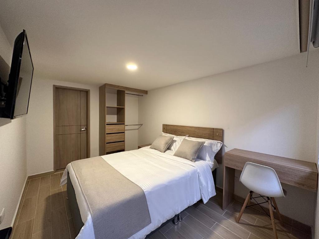 1 dormitorio con cama, escritorio y silla en One Fourteen Rooms en Bogotá