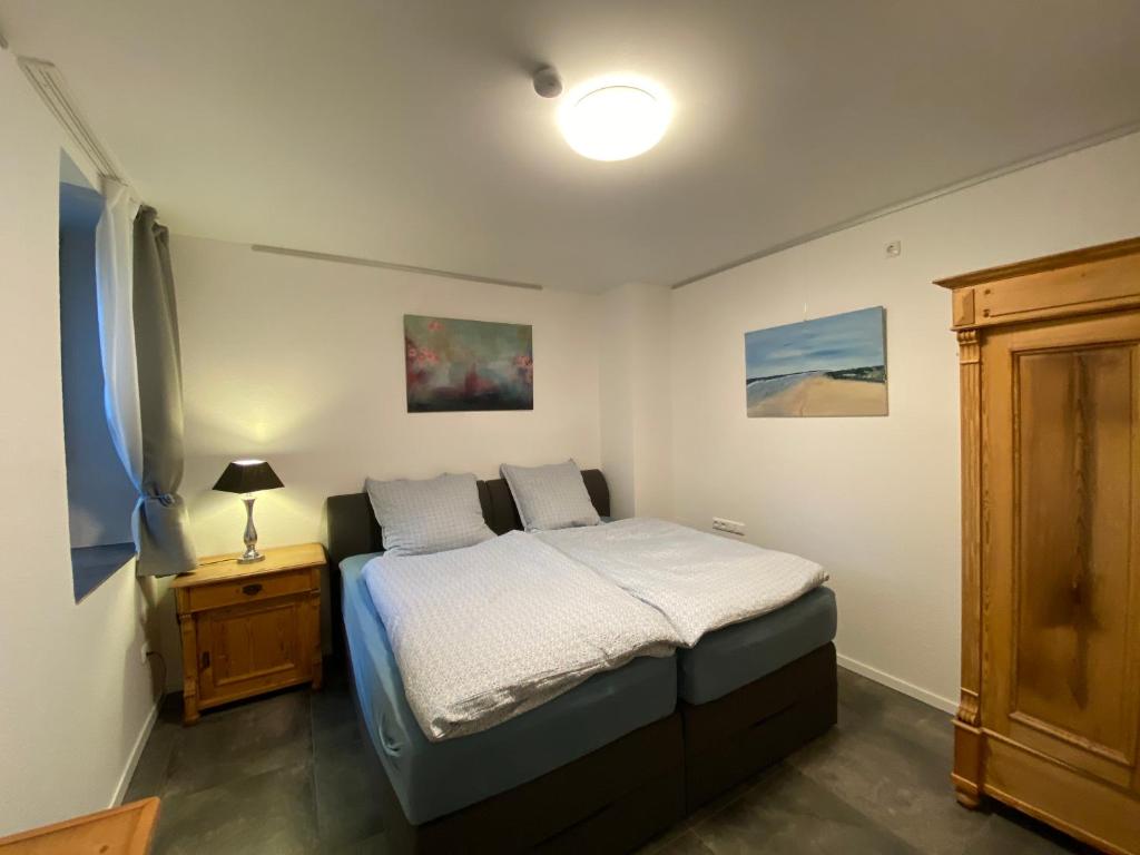- une petite chambre avec un lit et une table de nuit dans l'établissement Bella Casa, à Hagen