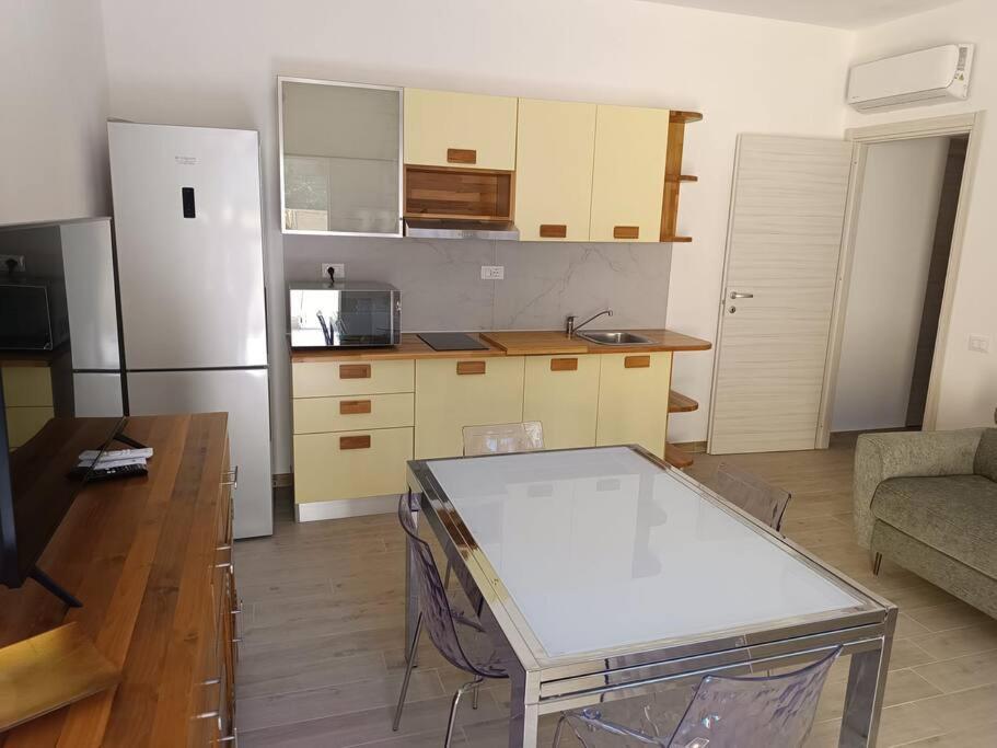 a small kitchen with a table and a refrigerator at suite4relax - near poetto beach in Quartu SantʼElena