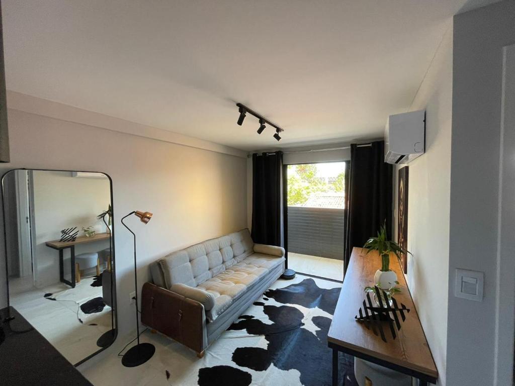 sala de estar con sofá y espejo en Apartamento Moderno em Tambauzinho. 2km da praia! en João Pessoa