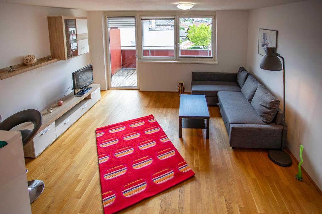 a living room with a couch and a red rug at Apartment Central Fulpmes + free parking spot in Fulpmes