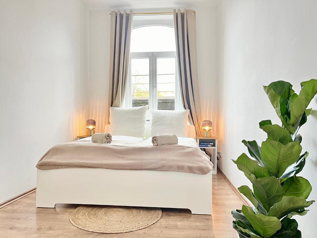 białe łóżko w pokoju z oknem w obiekcie Golden Deer Apartment - 3 Schlafzimmer - Zentrum - 92m² w Hanowerze