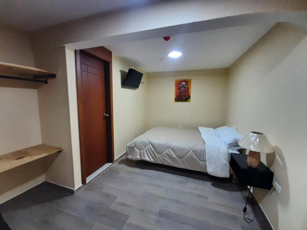 a hotel room with a bed and a door at Mi casa in Latacunga