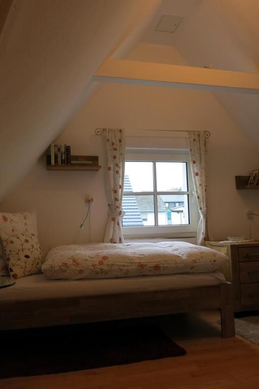 a bedroom with a bed with a window at Ferienhaus Julius in Willingen