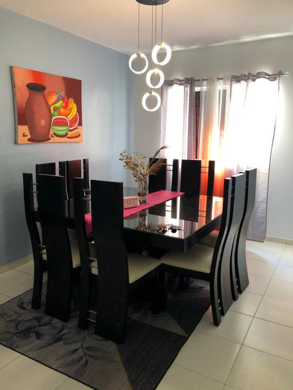 a dining room with a black table and chairs at Residencial Felipe 2 in Santo Domingo
