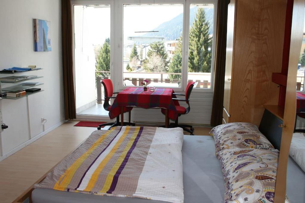 sala de estar con mesa y sofá en MicroAppartment with bath and cozy balcony en Davos