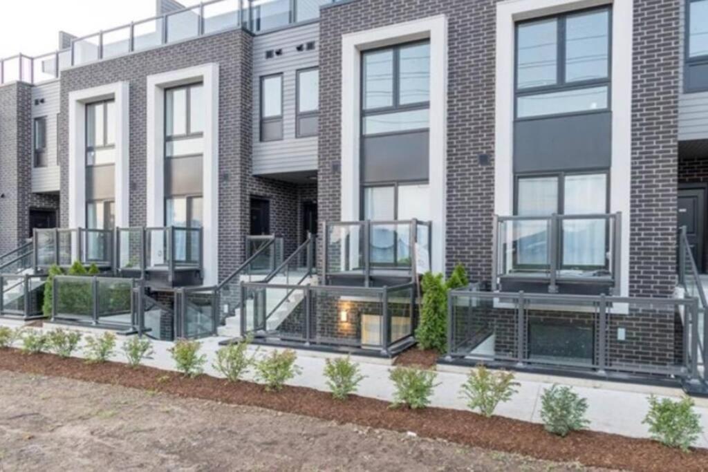 an apartment building with stairs in front of it at Exquisite, bright & modern condo. in Niagara Falls