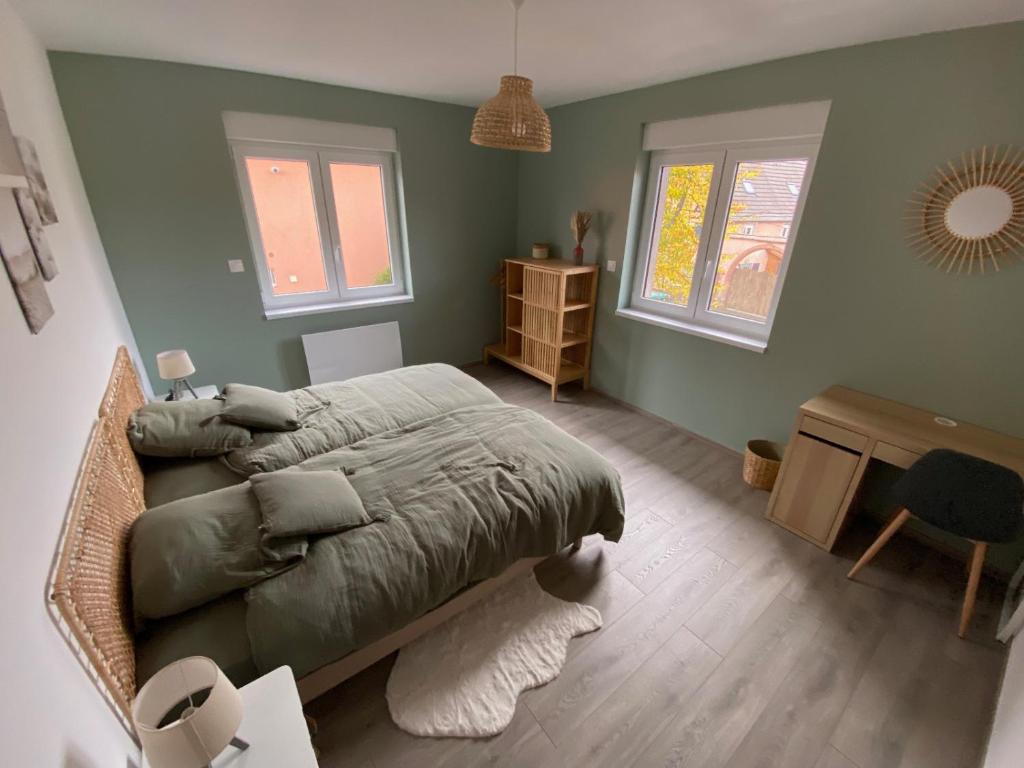 - une chambre avec un lit, un bureau et 2 fenêtres dans l&#39;établissement Chez Sim et Vava, à Scherwiller