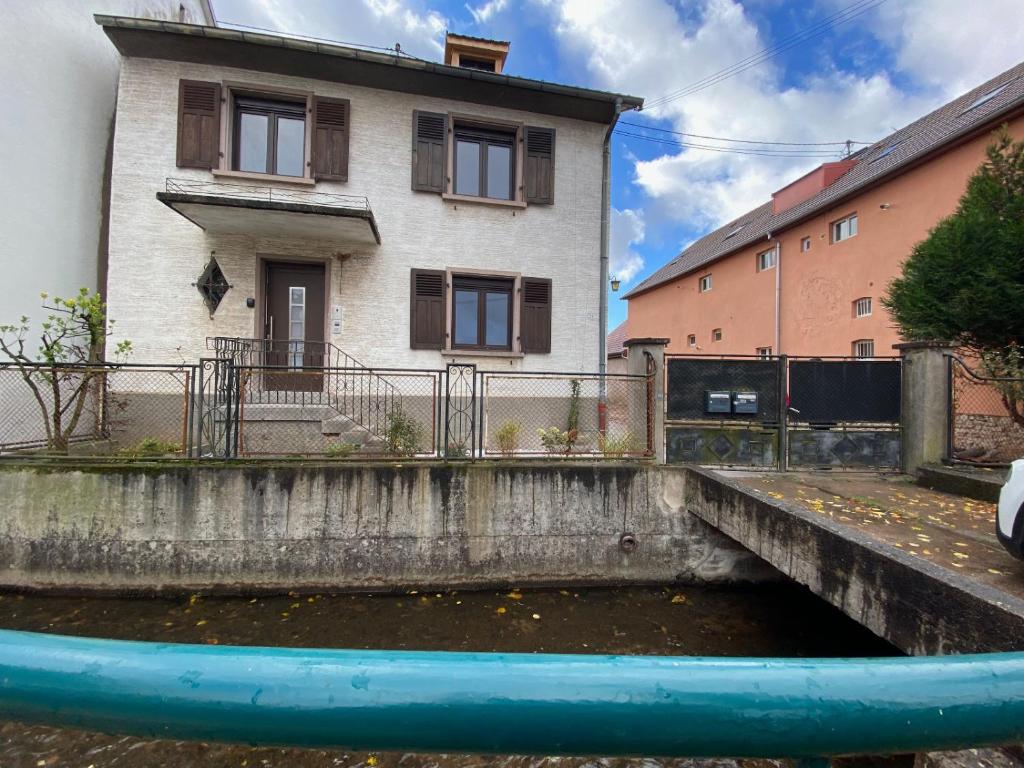 une piscine d&#39;eau en face d&#39;une maison dans l&#39;établissement Chez Sim et Vava, à Scherwiller