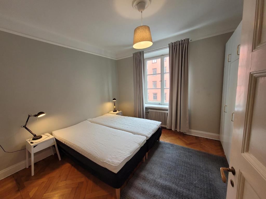 Home Inn FKG110 في ستوكهولم: غرفة نوم صغيرة بها سرير ونافذة