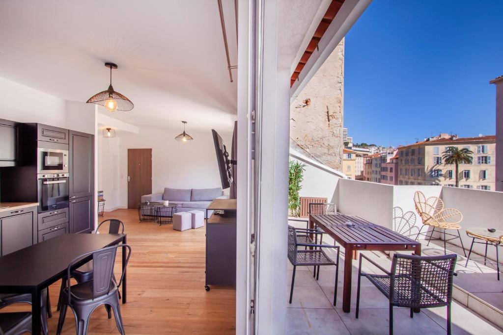 eine Küche und ein Wohnzimmer mit Tisch und Stühlen in der Unterkunft Les Suites R Bonaparte - Appartements de standing au cœur de la vieille ville piétonne in Ajaccio
