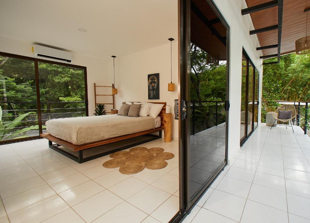 1 dormitorio con 1 cama y puerta de cristal grande en Deluxe Loft 1 BDR con linda vista, en Puntarenas