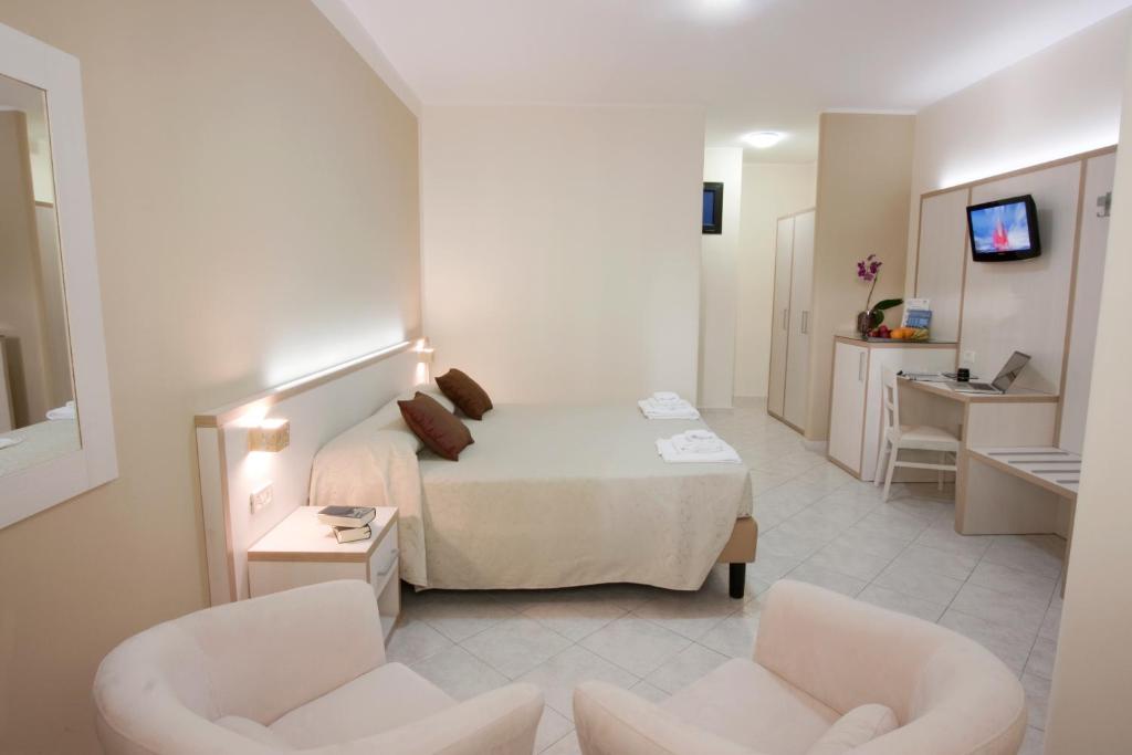 a hotel room with a bed and two chairs at Hotel Residence Nemo in Brindisi