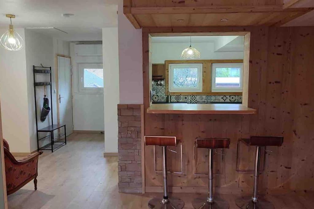 a kitchen with a bar with stools and a mirror at ski chamonix, Saint Gervais et mont-blanc in Passy