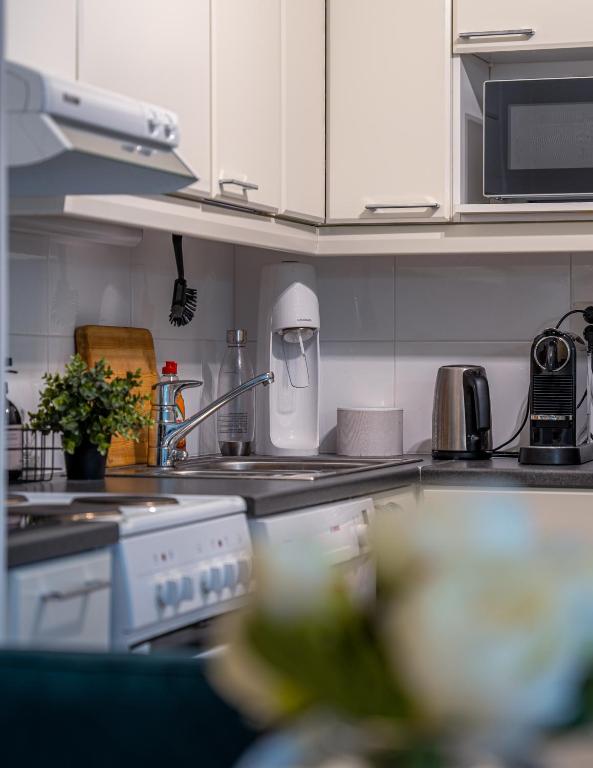 a kitchen with white cabinets and a counter top at Aurora Breeze Residence - City Center in Rovaniemi