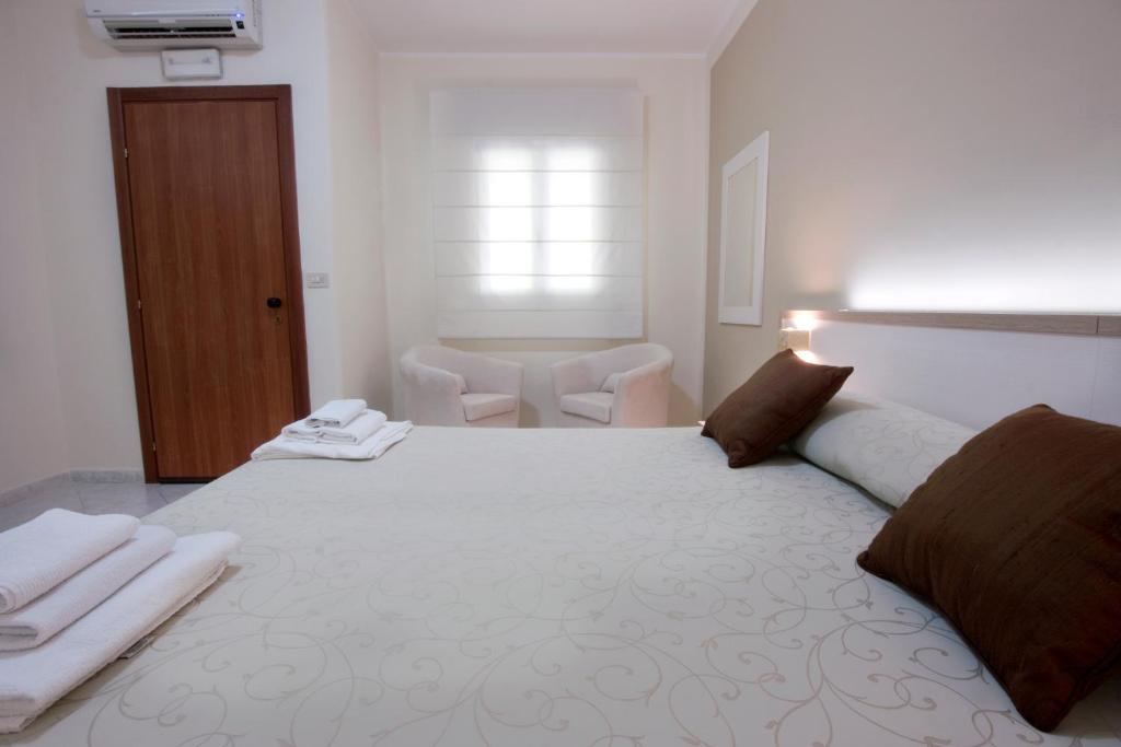 a bedroom with a large white bed with towels on it at Hotel Residence Nemo in Brindisi
