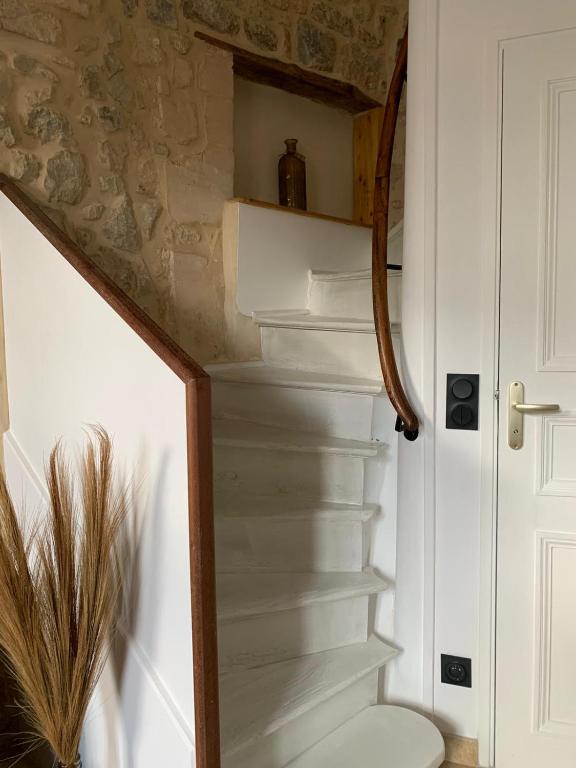 - un escalier dans une maison avec un escalier blanc dans l'établissement Charmante petite maison, à Saint-Vigor-le-Grand