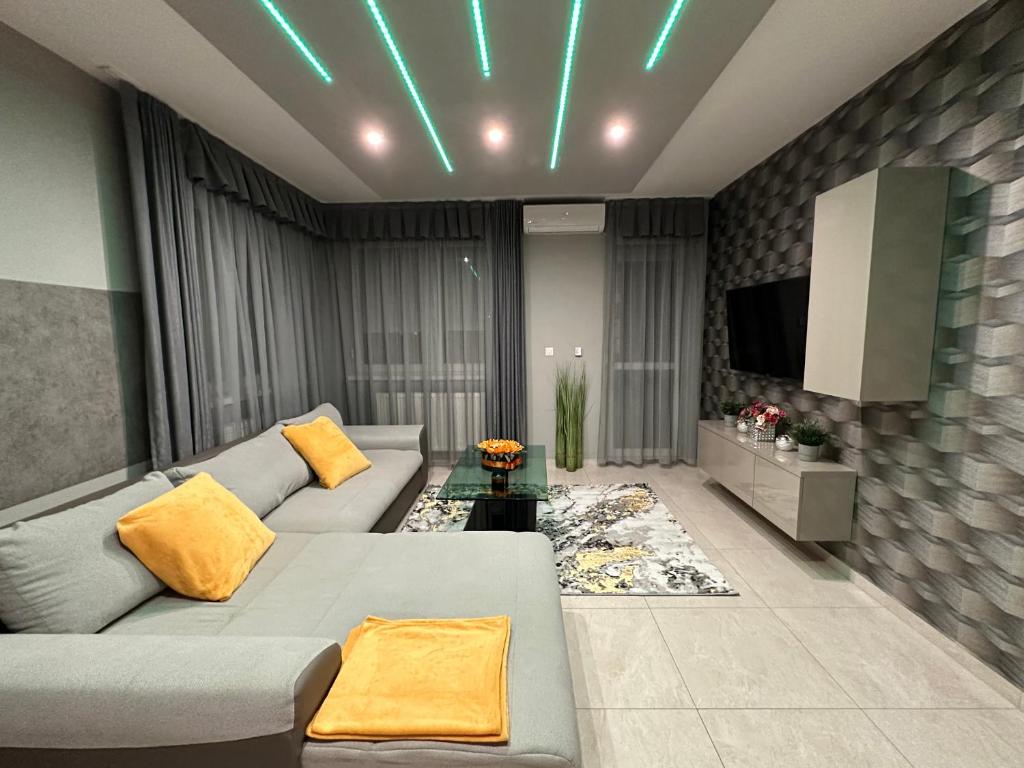 ein Wohnzimmer mit einem Sofa und einem TV in der Unterkunft NEW APARTMAN in Debrecen