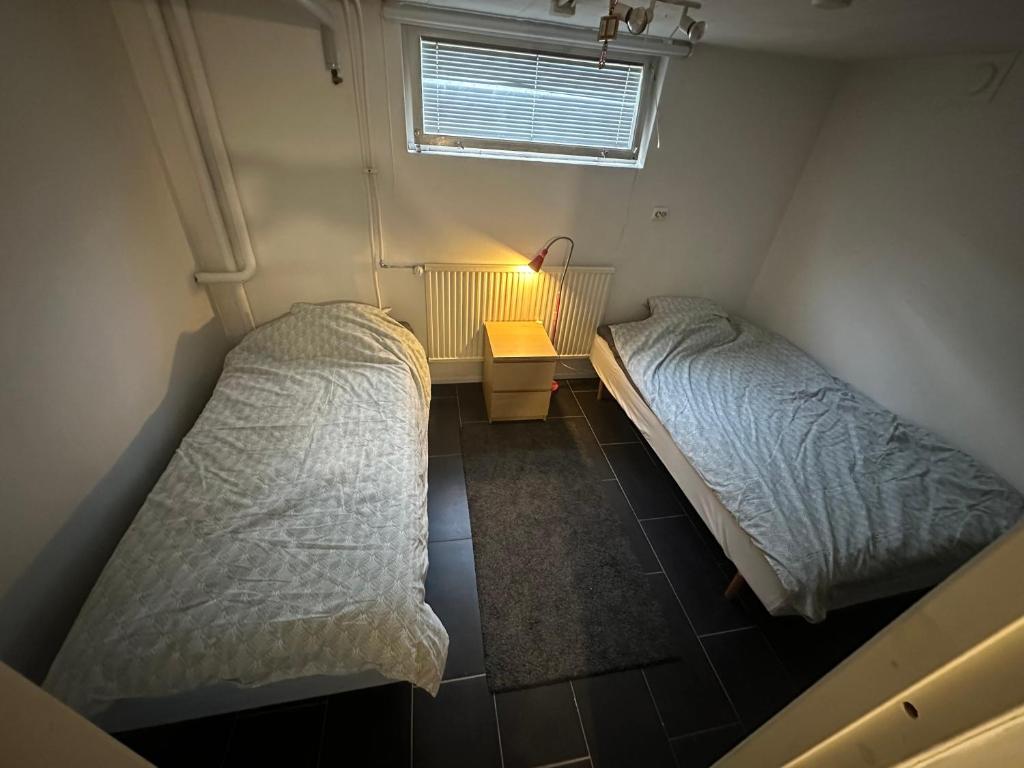 a room with two beds and a table and a window at Rum C Dammfrivägen 55 in Södervärn