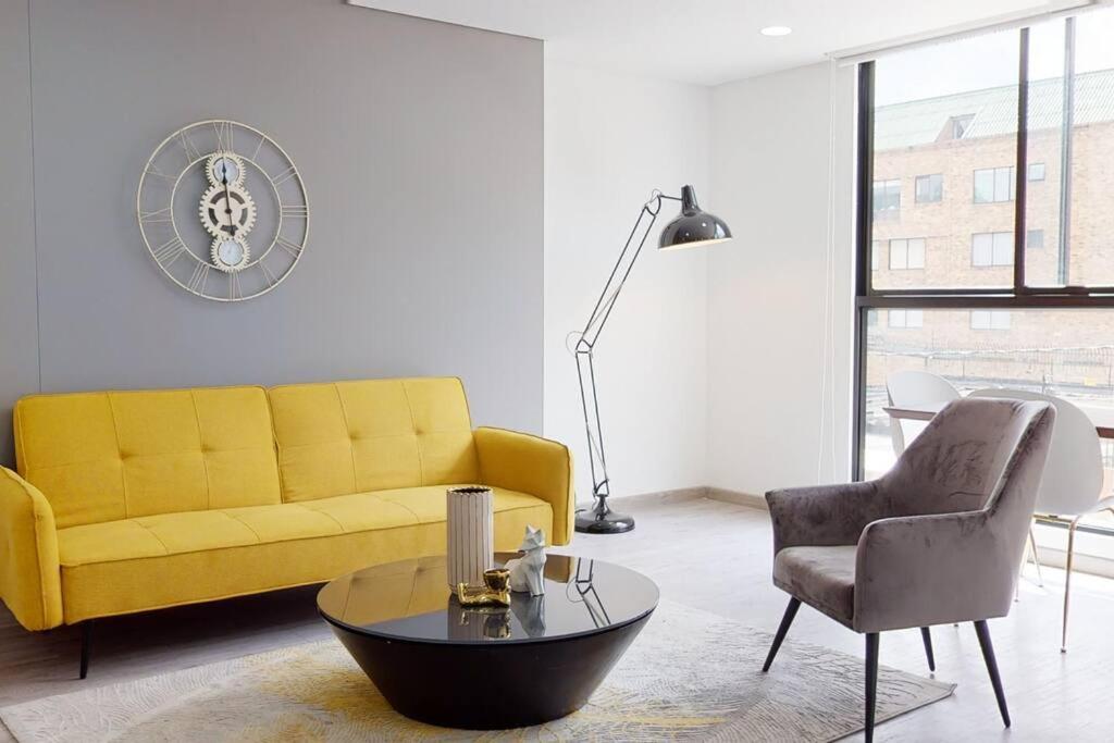 uma sala de estar com um sofá amarelo e uma cadeira em Apartamento 2 habitaciones Unicentro Scape em Bogotá