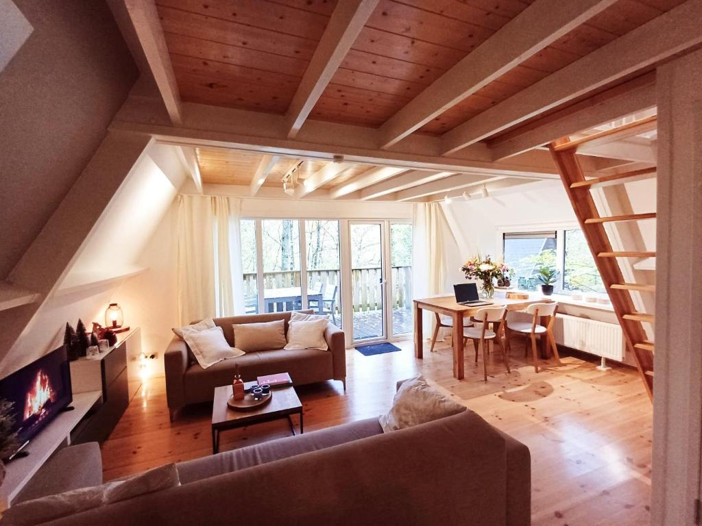 A Wood Lodge - zwembad - relax - natuur في دربي: غرفة معيشة مع أريكة وطاولة