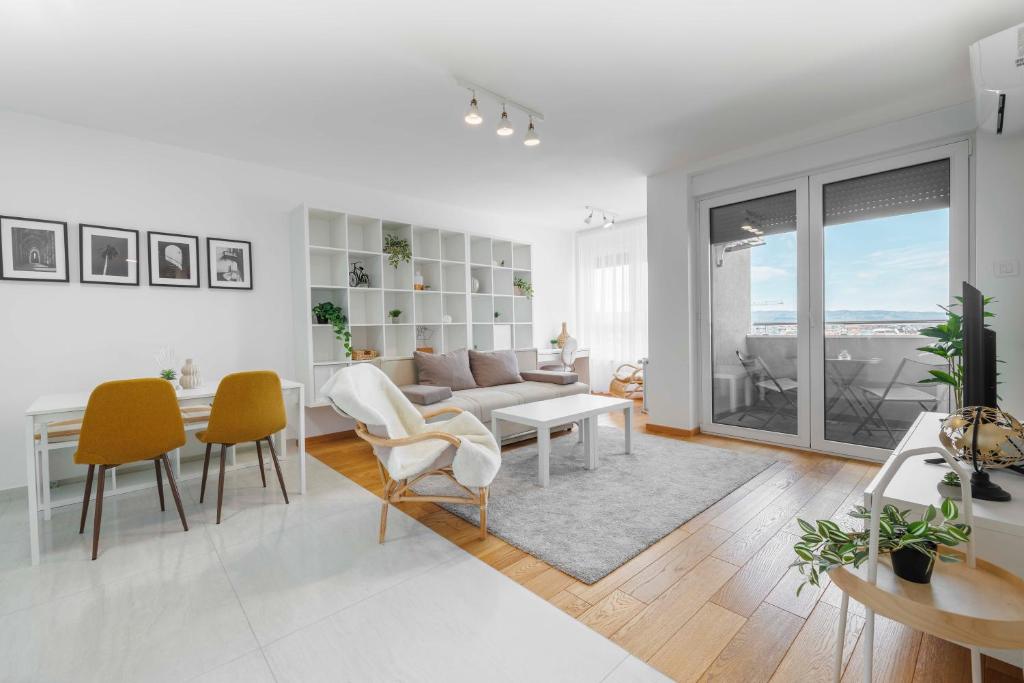 Una sala de estar con un sofá, una mesa y sillas. en Panta Rhei Luxury Apartments, en Novi Sad