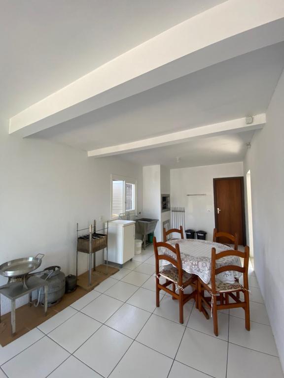 a kitchen and dining room with a table and chairs at Casa Bellatorres in Passo de Torres