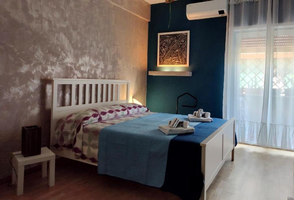 a bedroom with a bed with a blue wall at Euforbia House in Lido di Ostia
