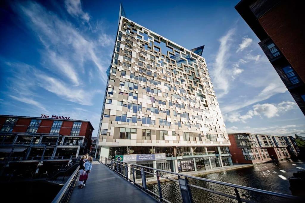 a tall building with people standing in front of it at Luxury Studio Apartment The Cube Birmingham City Centre in Birmingham