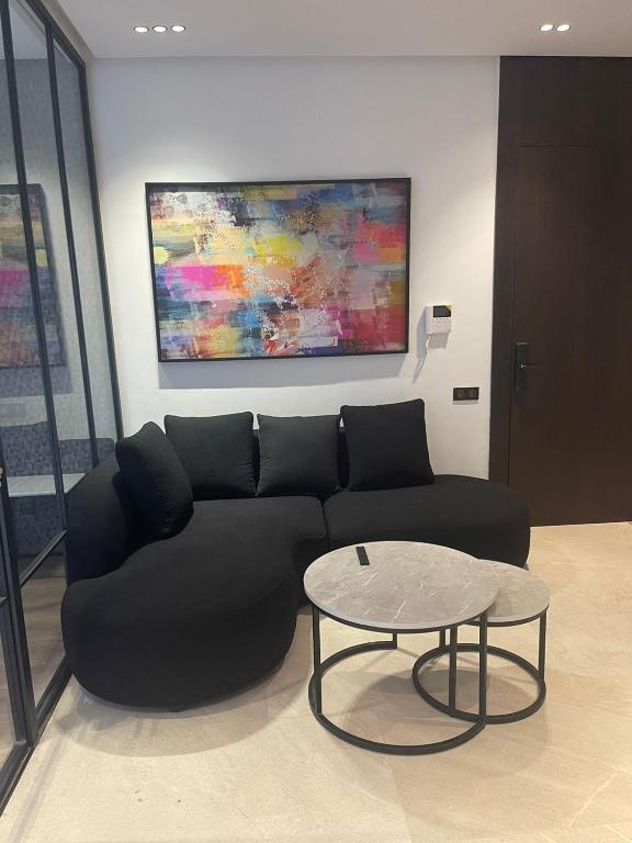 a living room with a black couch and a table at Magic Appartement Luxury Gauthier 04 in Casablanca