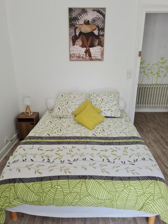 Una cama con una almohada amarilla encima. en Le st jean 1 en Saint-Jean-de-la-Porte