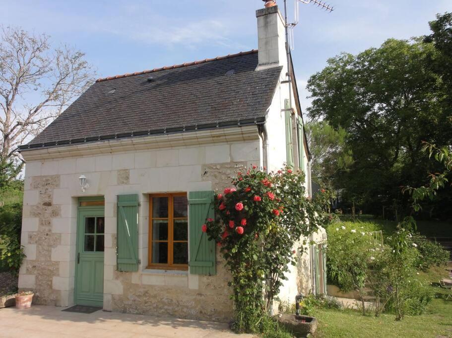 uma pequena casa branca com uma área de flores em Gîte de charme au cœur du saumurois 
