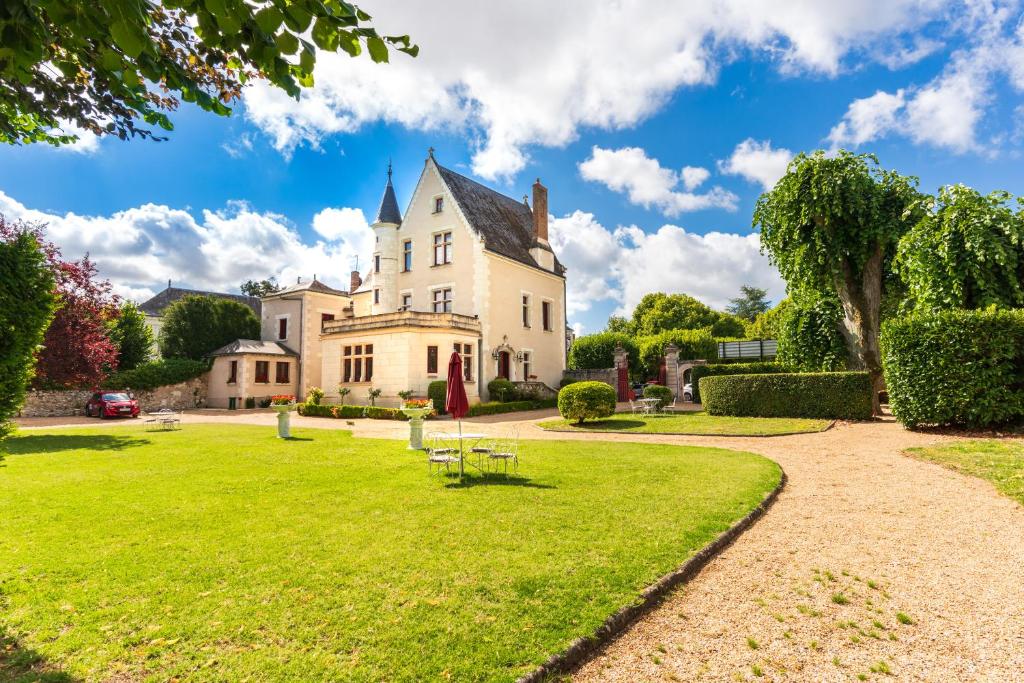 une grande maison blanche avec une cour en herbe dans l'établissement Le Manoir Saint Thomas, à Amboise