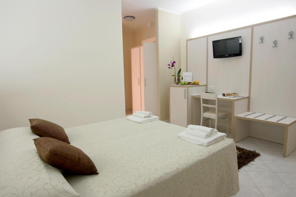 1 dormitorio con cama con almohadas y escritorio en Hotel Residence Nemo, en Brindisi