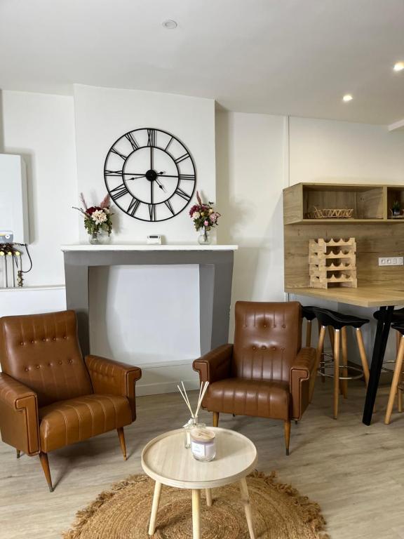 a living room with leather chairs and a clock at Maison Floirac Arkea Arena in Floirac