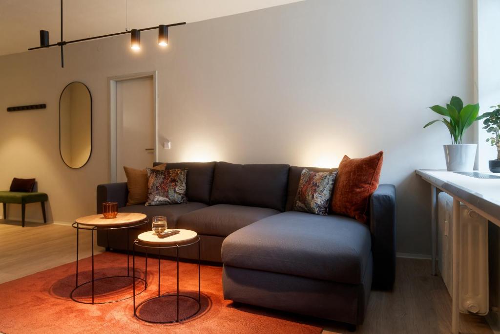 ein Wohnzimmer mit einem Sofa und 2 Tischen in der Unterkunft City Center Unique Boutique Apartment in Hamburg