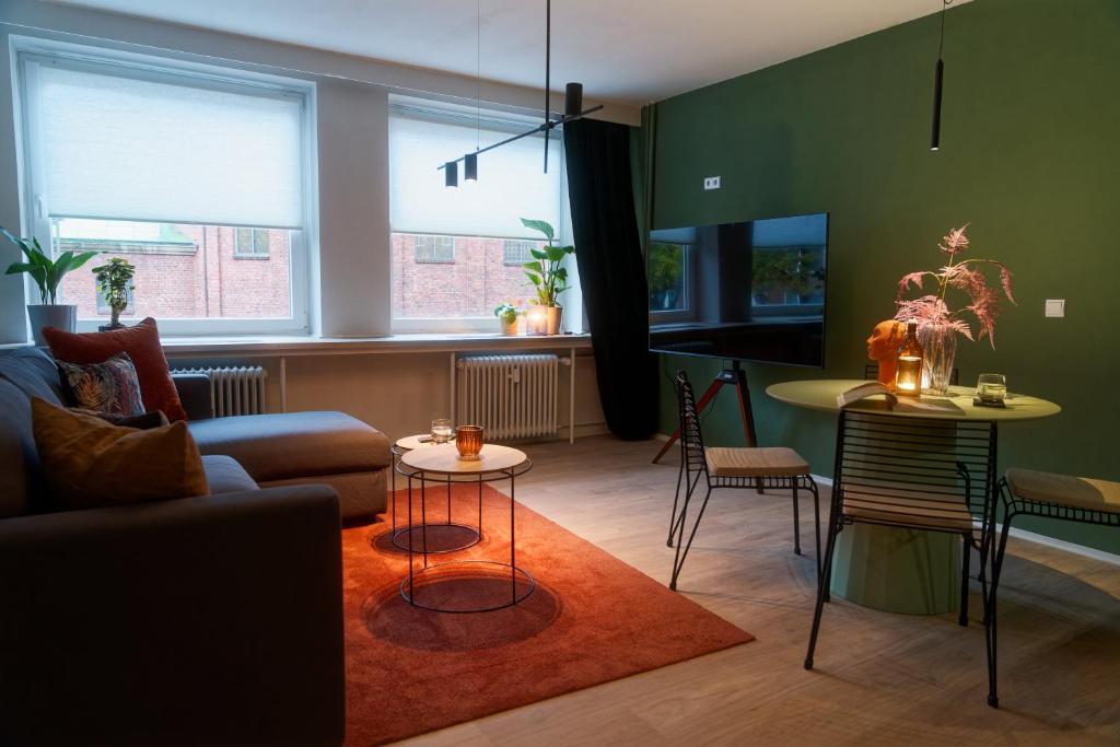 een woonkamer met een bank, een tafel en stoelen bij City Center Unique Boutique Apartment in Hamburg
