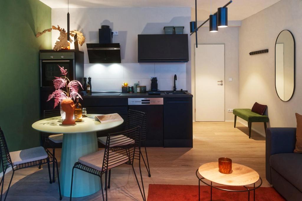 een woonkamer en een keuken met een tafel en stoelen bij City Center Unique Boutique Apartment in Hamburg