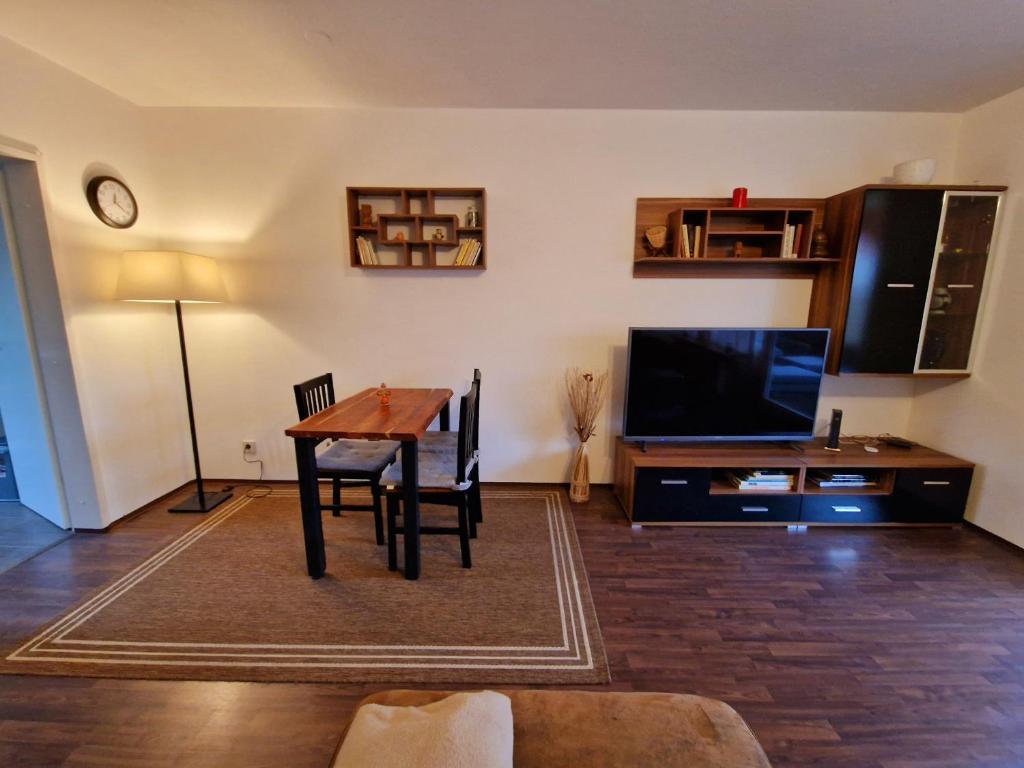 ein Wohnzimmer mit einem Tisch und einem Flachbild-TV in der Unterkunft 2-Zimmer Messe-Apartment Nbg-Langwasser 60qm in Nürnberg