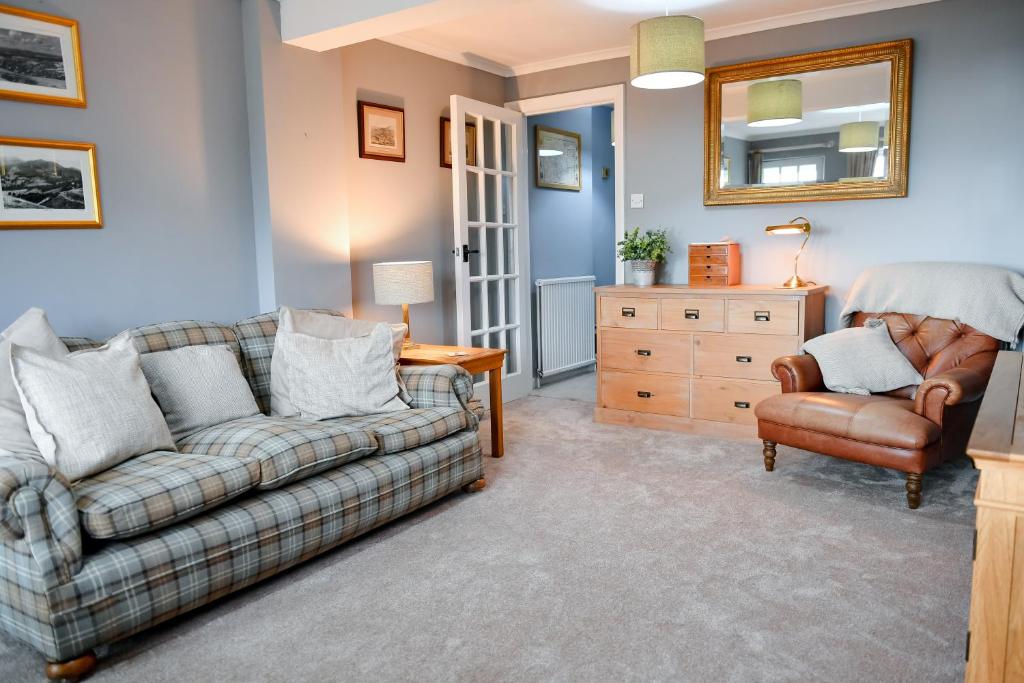 Charming Malvern Cottage with Outstanding Views في مالفيرن ويلز: غرفة معيشة مع أريكة وكرسي