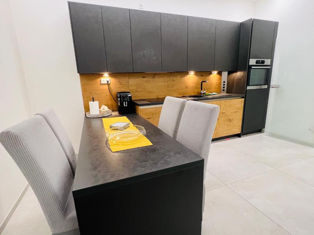 a kitchen with a black table and white chairs at Appartement - Rue du Canal in Esch-sur-Alzette