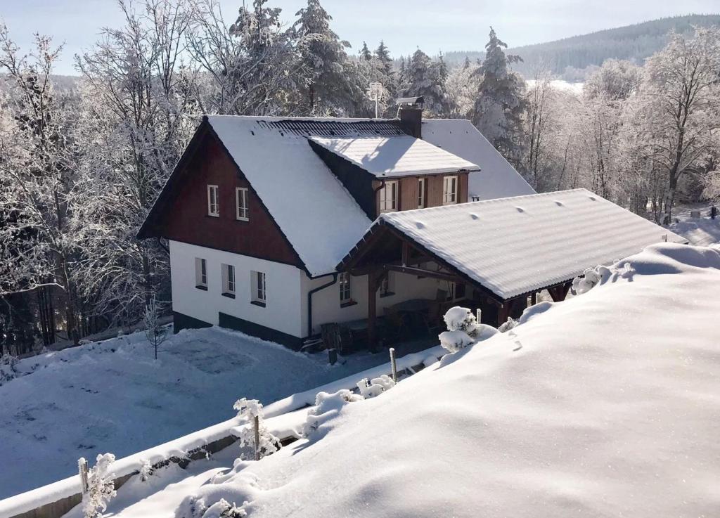 a house covered in snow with snow covered roofs at Chata Zadov in Prachatice