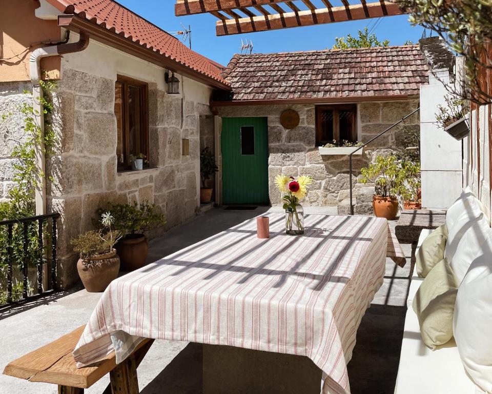 una mesa con mantel en el patio en Casa rural familiar con vistas al rio en Galicia en Puentesampayo