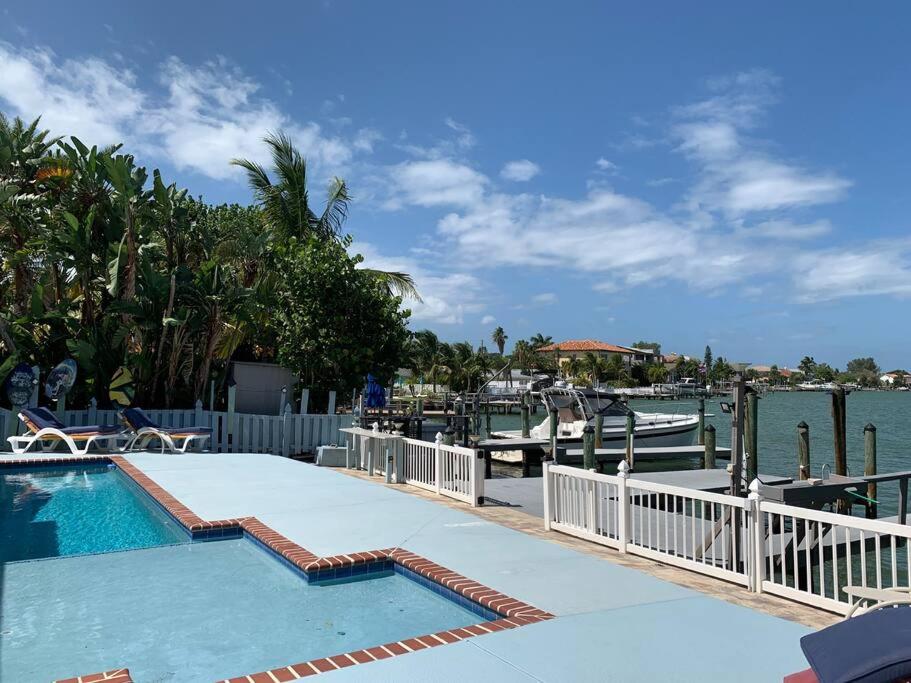 a swimming pool next to a marina with boats at Oceanview home on Indian Rocks Beach in Clearwater Beach